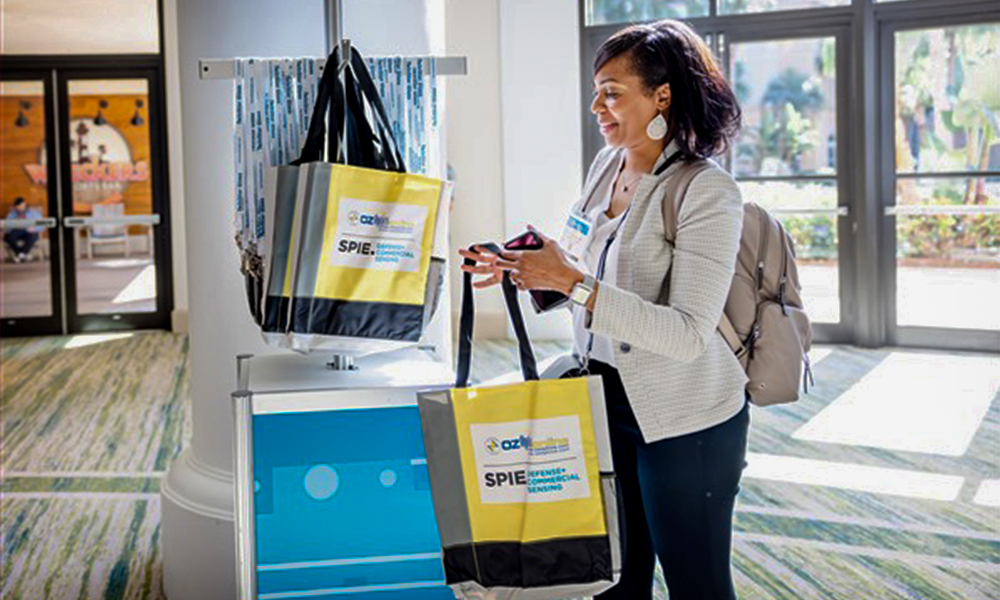 Attendee grabs a sponsored conference tote bag