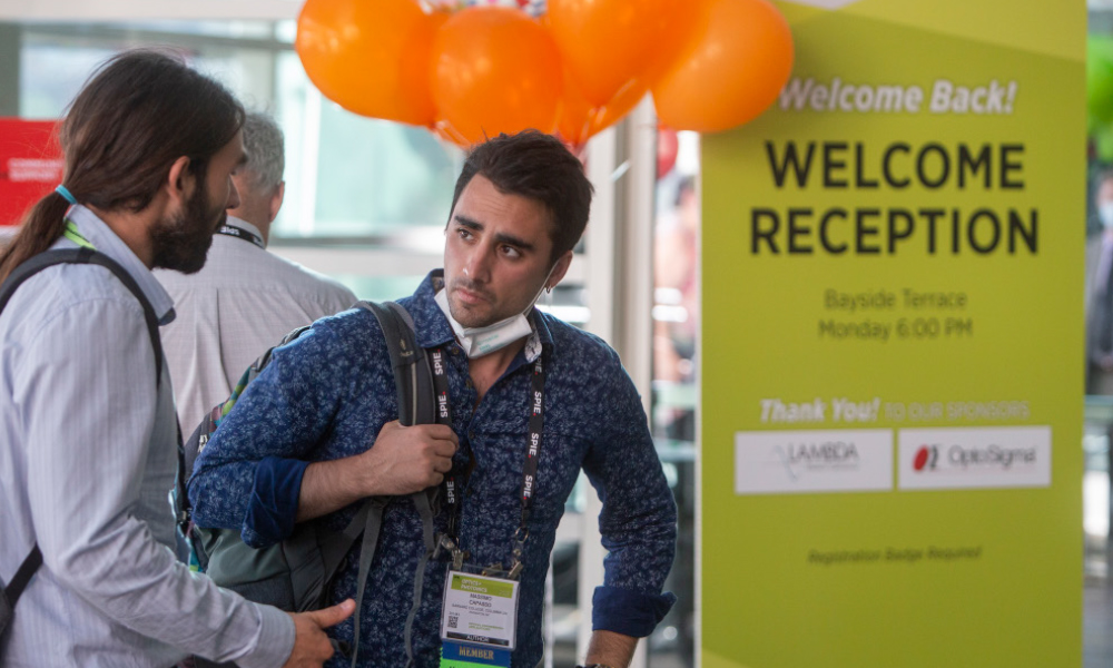 Attendees in front of Welcome Reception sponsor signage