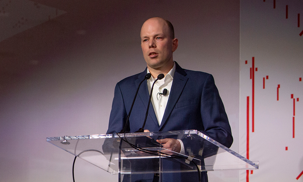 Man stands at podium, shares industry insights at SPIE Global Business Forum