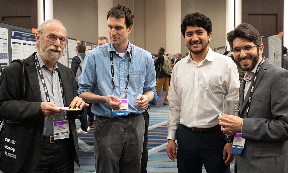 Four attendees share a networking moment together at a technical event