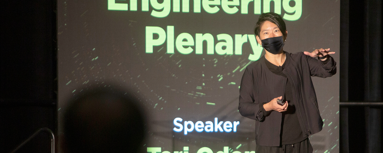 Masked speaker addresses the audience from the podium for SPIE Advanced Lithography + Patterning