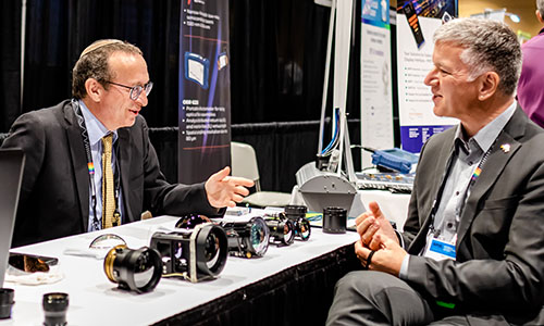 Exhibitioner talking with an attendee at SPIE Defense + Commercial Sensing