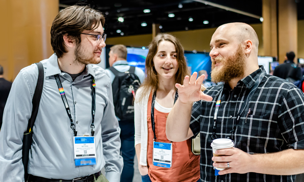 Three students connect at an SPIE exhibition