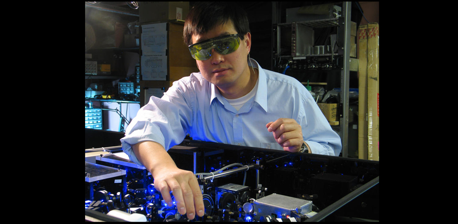 Physicist Jun Ye adjusts the laser setup for a strontium atomic clock in his laboratory at JILA 