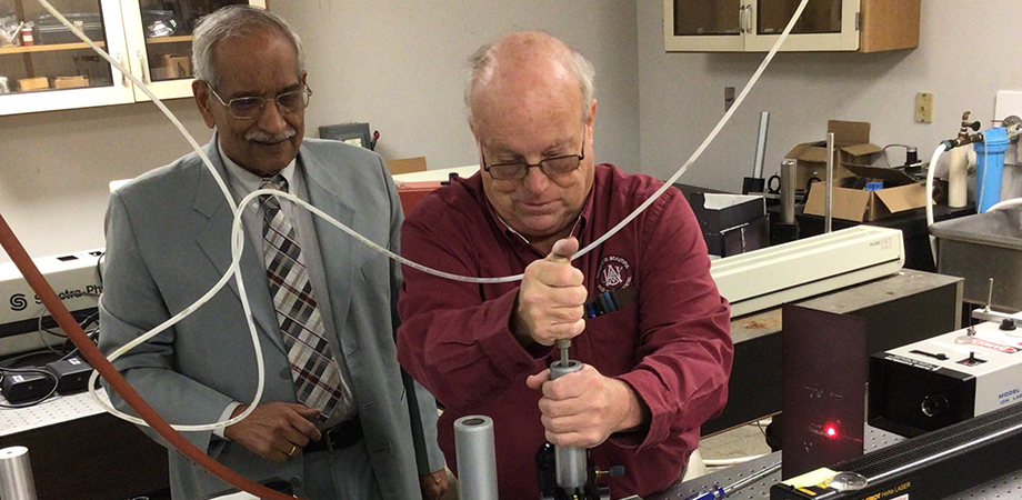Dr. Michael Curley, right, fixing a post in an experimental arrangement for recording gratings, with Dr. Rajpal Sirohi. 